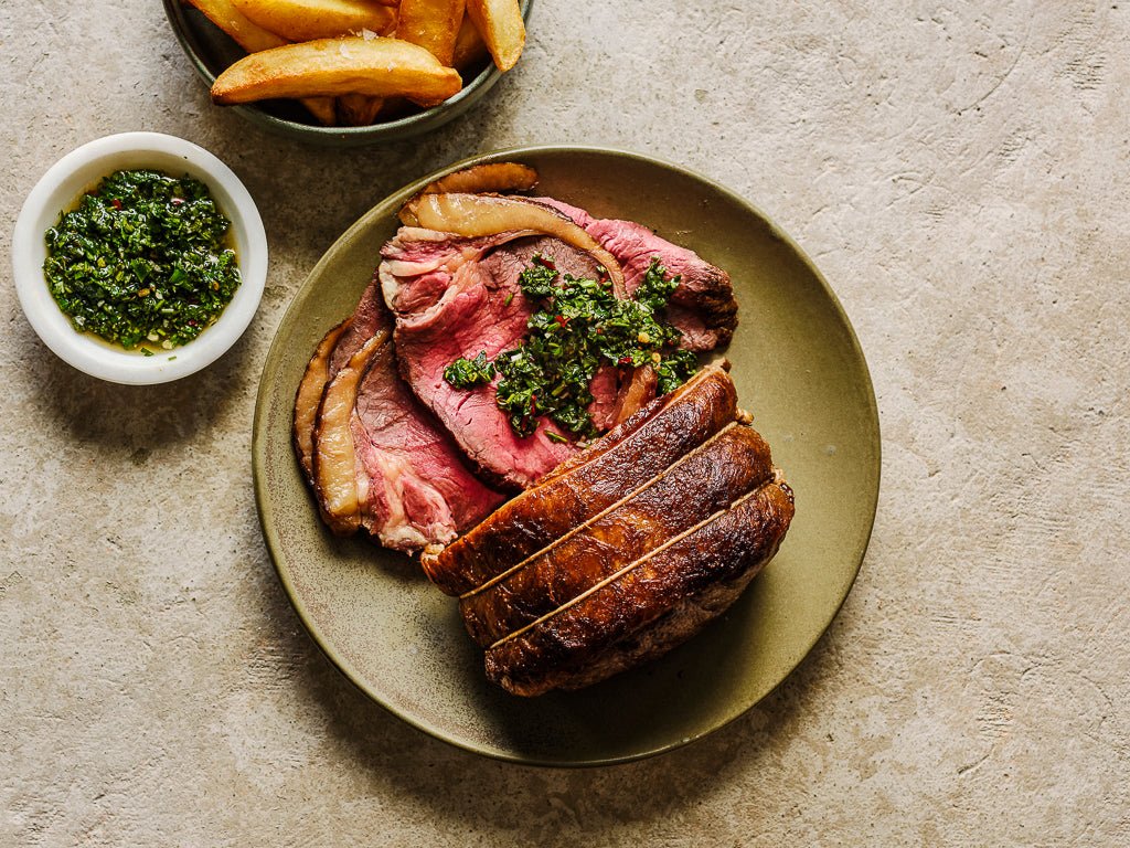 sirloin mini roast boned and rolled served slices with chimichurri and chunky chips (cooked dish)
